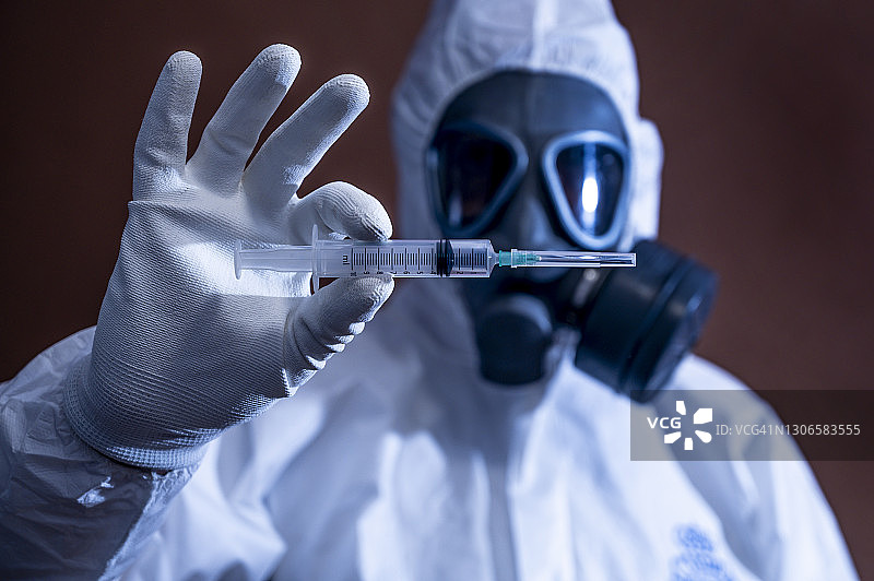 戴着防毒面具拿着注射器的中年男人图片素材