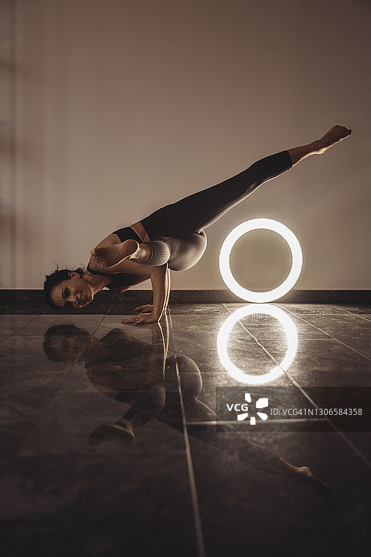 女人在家中环形灯前练习孔雀式图片素材