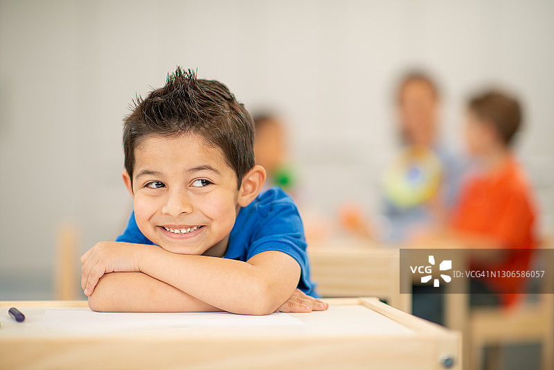 微笑的学龄前男孩在课堂上图片素材