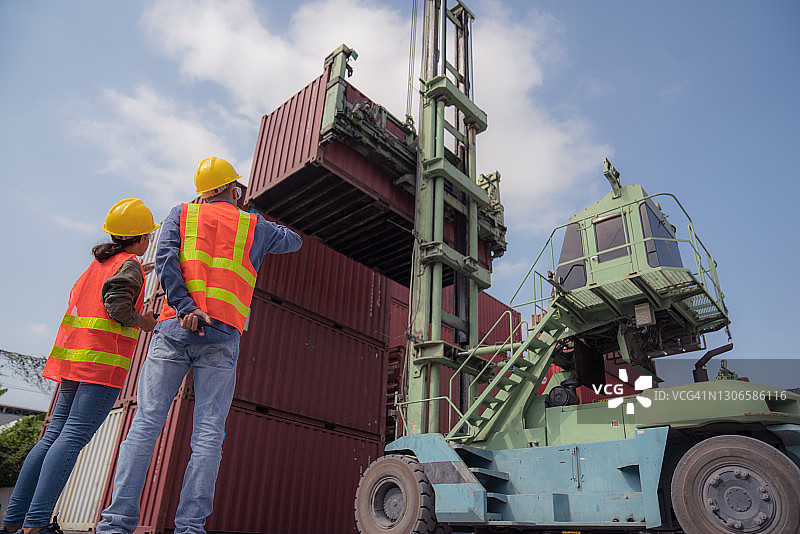 物流工人和起重机将集装箱装载到卡车上图片素材
