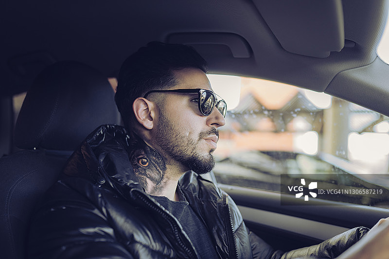 穿夹克开车看向别处的潮人图片素材