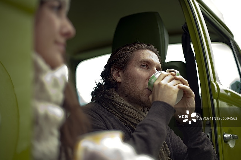 年轻男人喝咖啡时看向别处图片素材