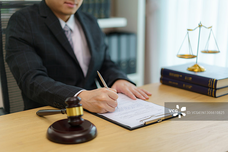 律师在办公室工作，公证员签署文件。顾问律师、司法和法律、律师、法院法官概念图片素材