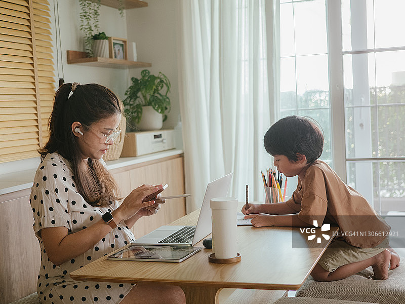 亚洲儿子和母亲在家参加在线课程图片素材