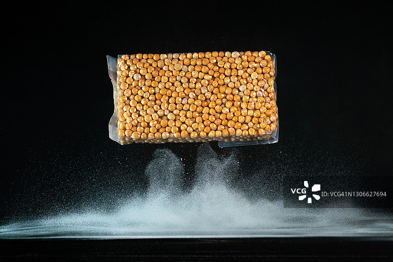 黑色背景中飞在半空中的包装豌豆图片素材