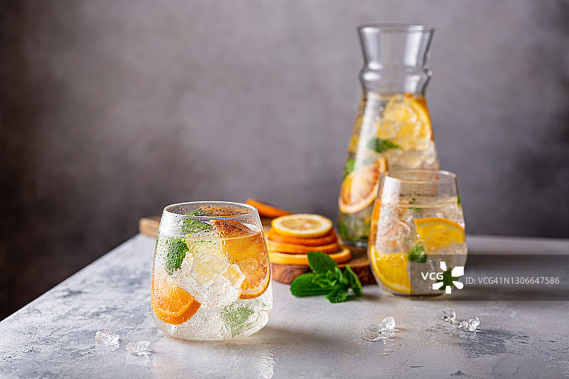 含碎冰、薄荷叶和橙子的新鲜鸡尾酒（夏季冷饮概念，带复制空间）图片素材