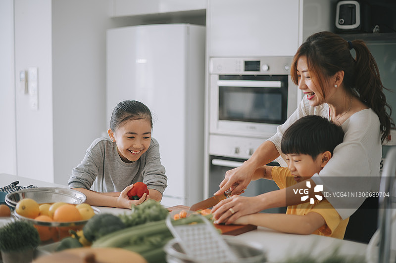 母亲教儿子切胡萝卜图片素材