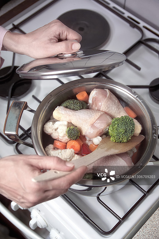 在锅中烹饪什锦蔬菜和鸡腿图片素材