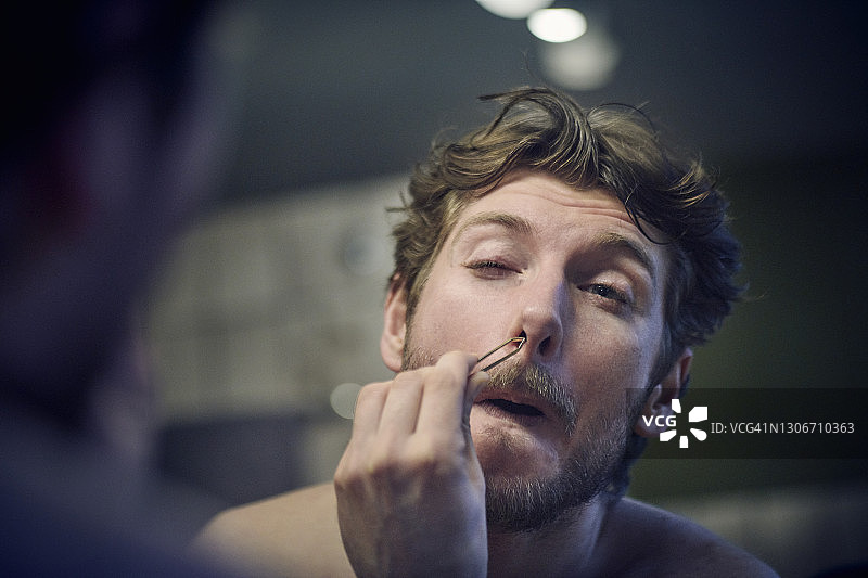 年轻男人拔鼻毛图片素材