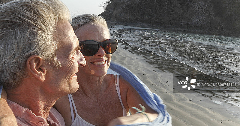 日出时分，年长夫妇在空旷的海滩上放松身心图片素材