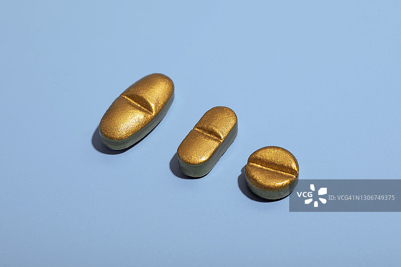 蓝色背景上的金色药丸图片素材