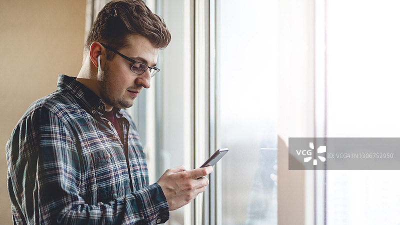 戴眼镜的现代成功男士肖像，休闲装扮，手提电脑和预留空间拍摄概念照片图片素材