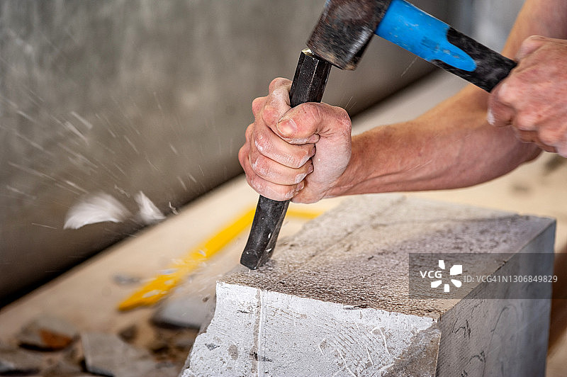 特写：石匠用凿子和锤子加工大理石图片素材