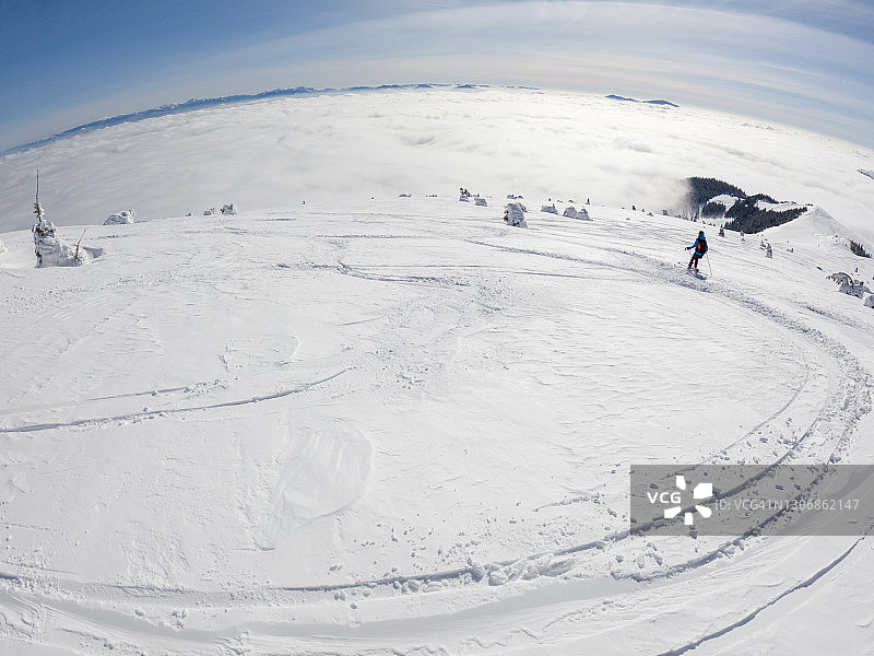 女性滑雪者进行粉雪转弯图片素材