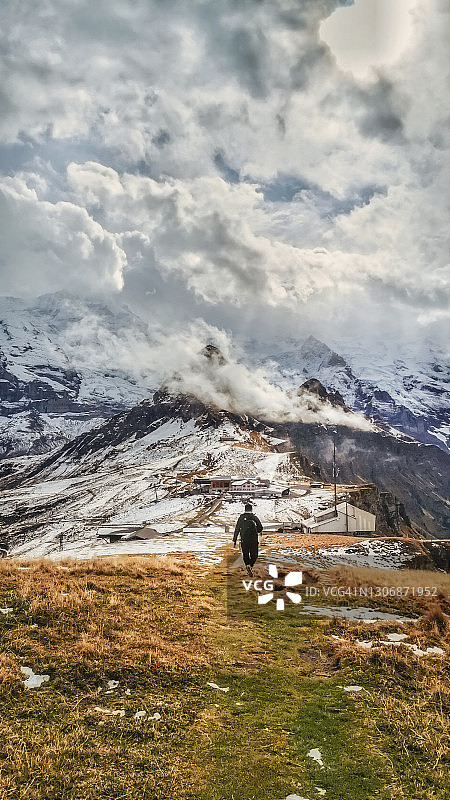 独自旅行的亚洲男人在秋天于瑞士少女峰雪山旅行（背面视角）图片素材