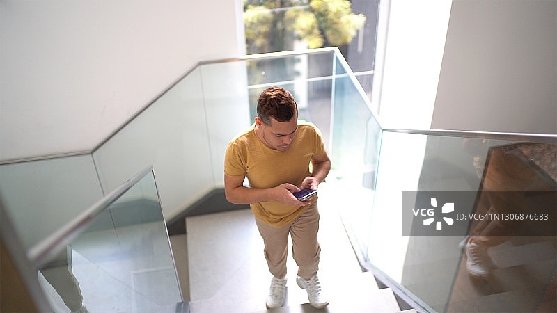 在家用手机发短信的侏儒症年轻人图片素材