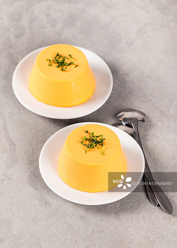 浅灰色背景盘装欧芹纯素胡萝卜布丁、意式奶冻图片素材