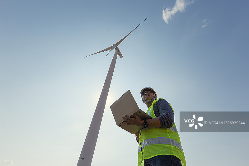 使用笔记本电脑检查风力涡轮机质量控制效率的工程师图片素材