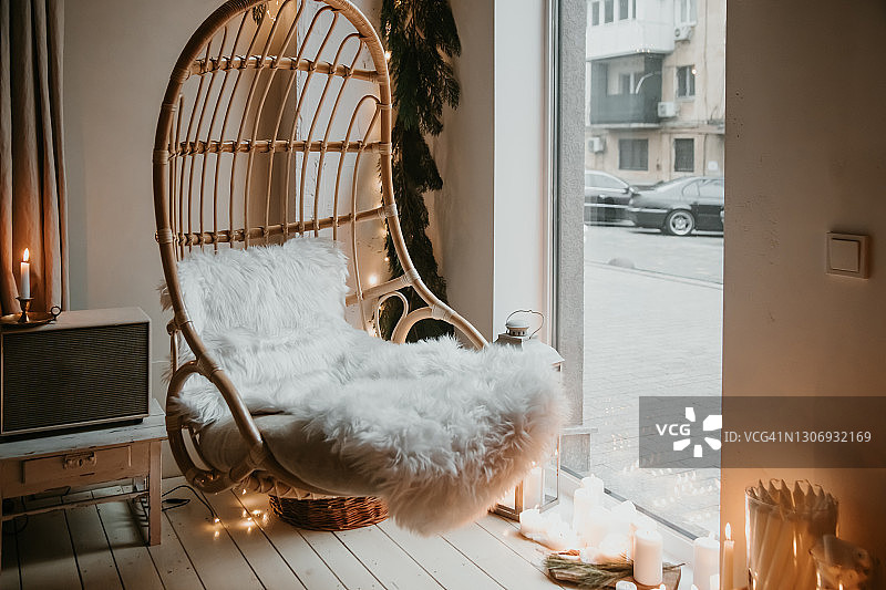带白色枕头的复古悬挂椅和地板上的蜡烛图片素材