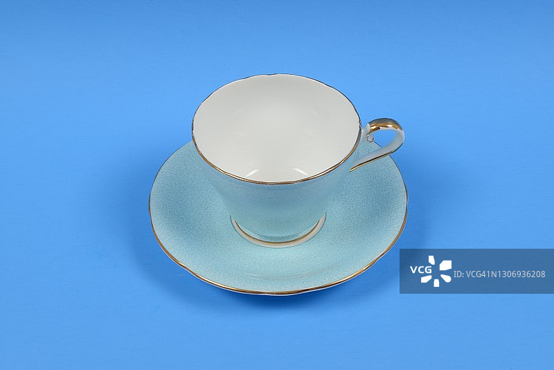 复古茶杯、茶托与蓝色背景图片素材