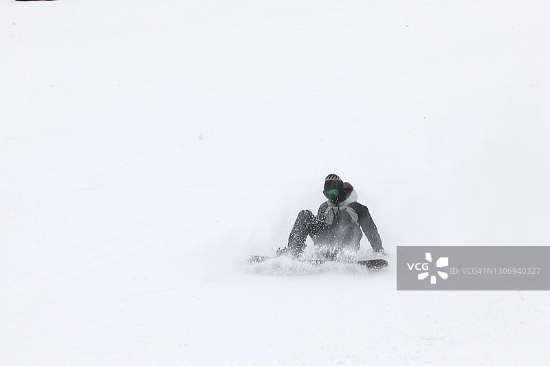 单板滑雪者雪中摔倒图片素材