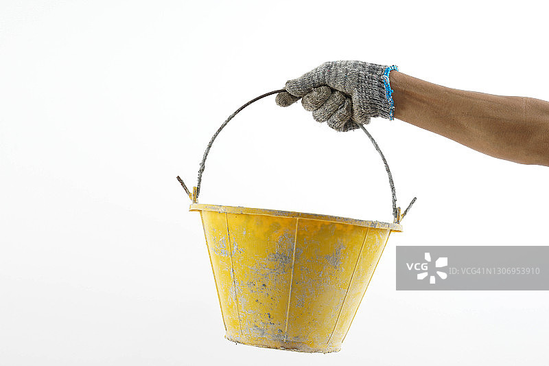 戴棉手套的手拿着白色背景中的黄色篮子图片素材