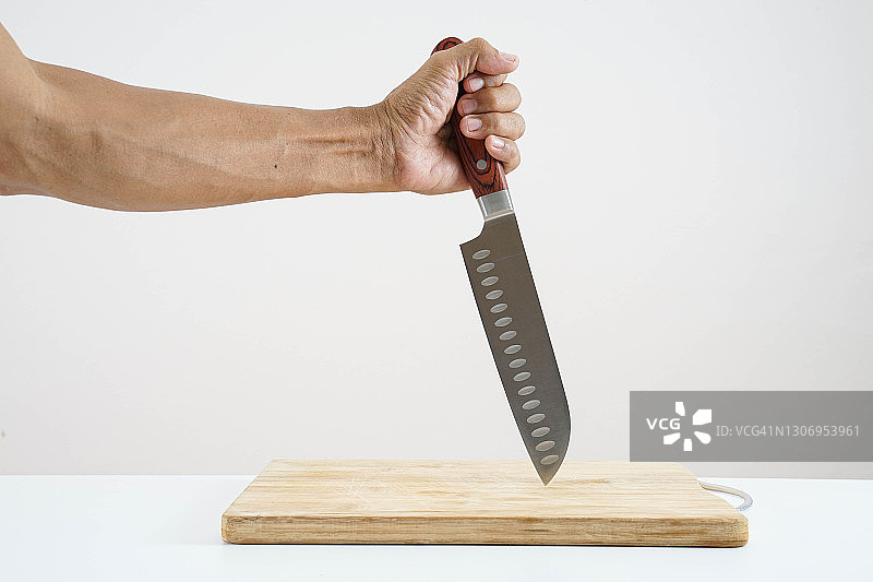 握着不锈钢刀在空的砧板上图片素材