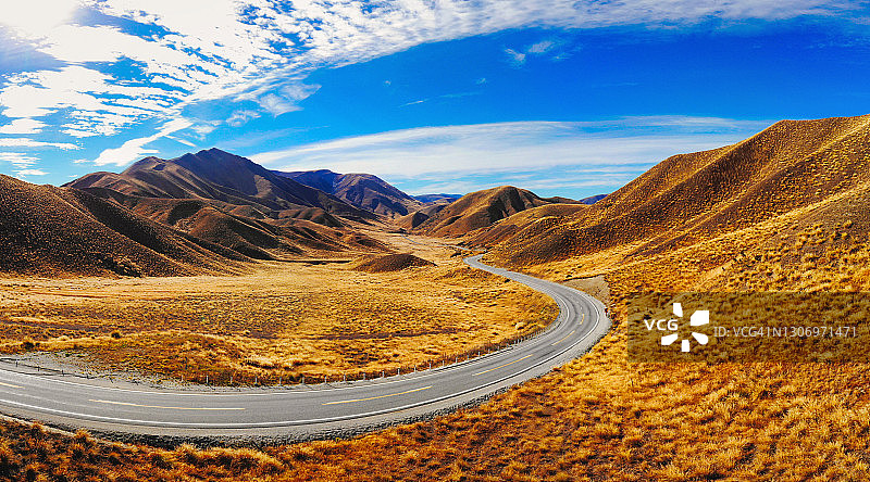 通往新西兰库克山的沥青公路弯道，蓝湖绿山日出航拍图片素材