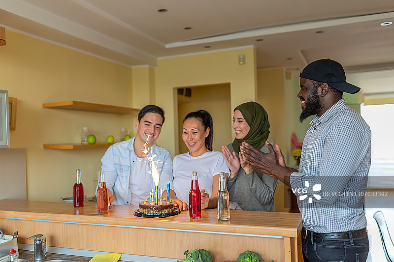一群快乐的年轻多元文化朋友正在为亚洲年轻女性庆祝生日，有生日蛋糕和饮料图片素材