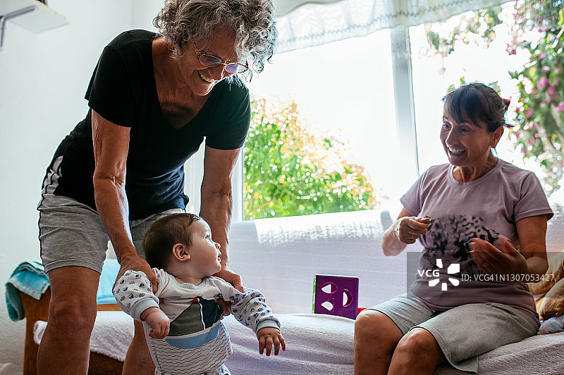 奶奶在家帮助孙子学习走路图片素材
