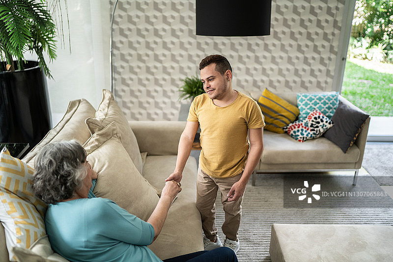 患有侏儒症的母子在家中分享温馨时刻。图片素材