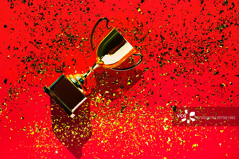 红色背景上的金色奖杯俯视图：目标达成概念图片素材