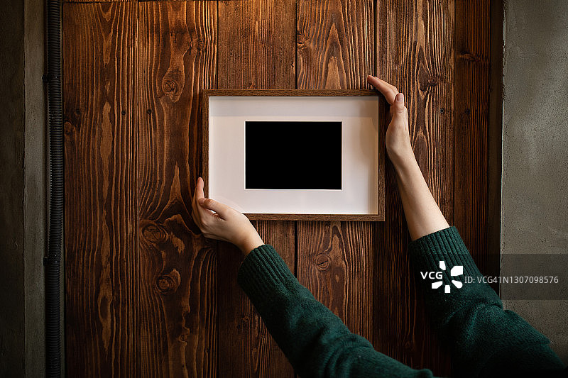 女人扶着墙上的相框图片素材