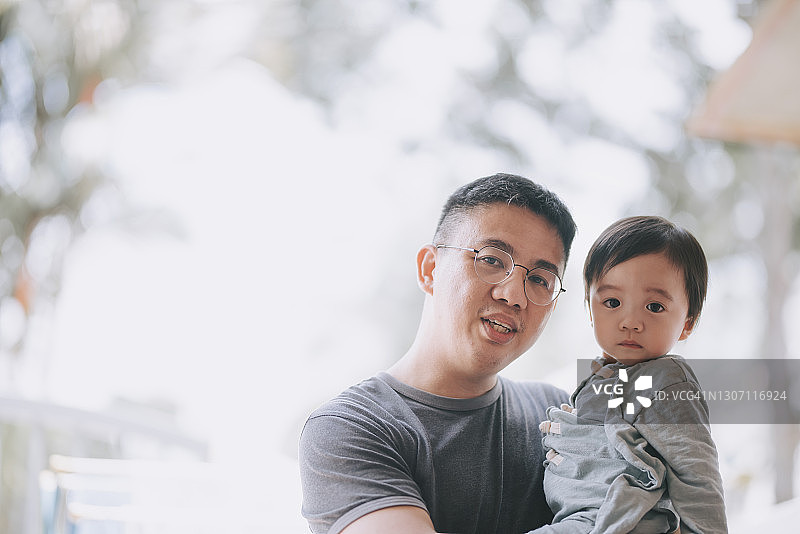 亚洲父亲户外抱着男婴图片素材