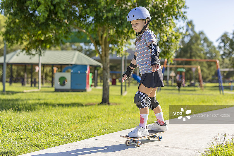 学习滑滑板的年轻女孩图片素材