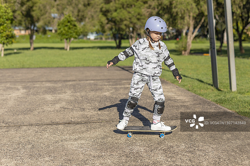 学习滑滑板的年轻女孩图片素材