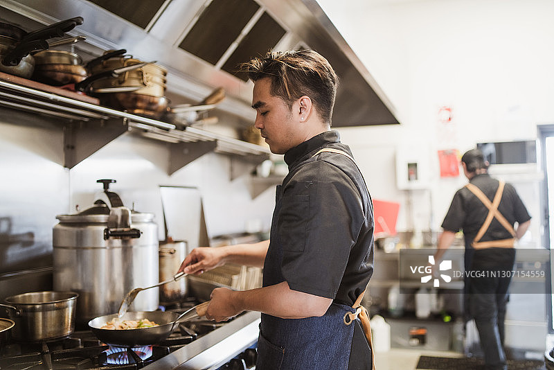 小型企业经营者在餐厅厨房准备菜肴图片素材