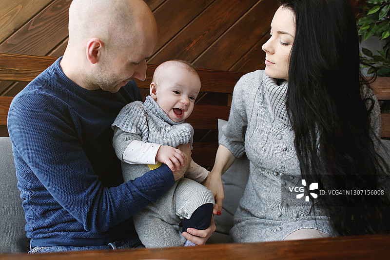 在咖啡馆里和父母一起玩耍的可爱幼儿女孩图片素材