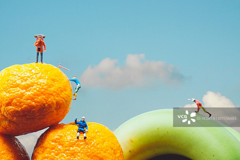 人体模型在云朵天空下攀爬橘子和香蕉图片素材