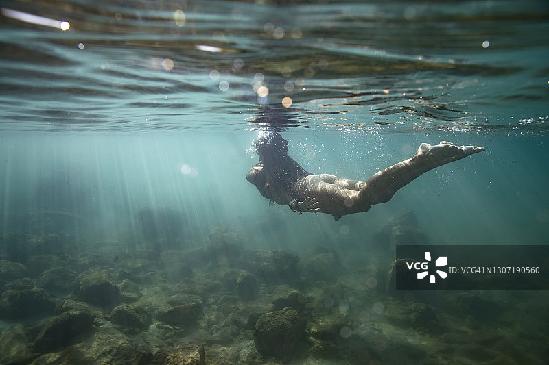 在浅海海面向上游的女游泳者图片素材