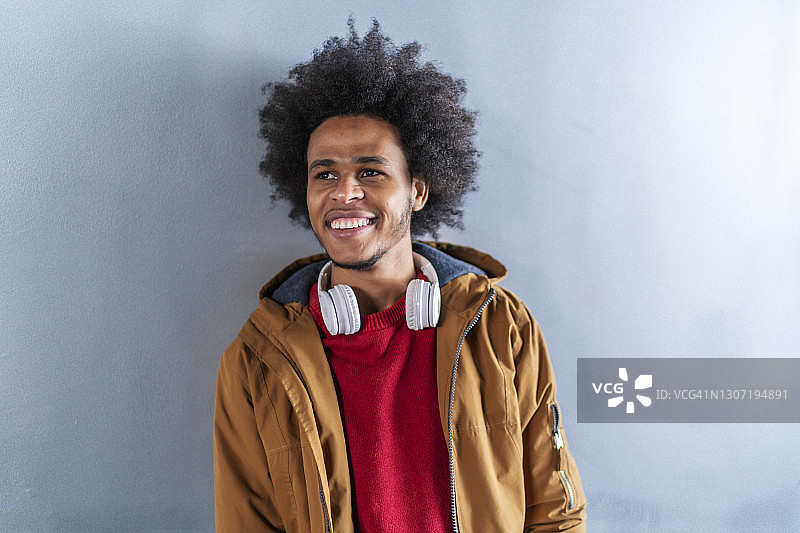 灰色墙壁上的爆炸头年轻男子肖像图片素材