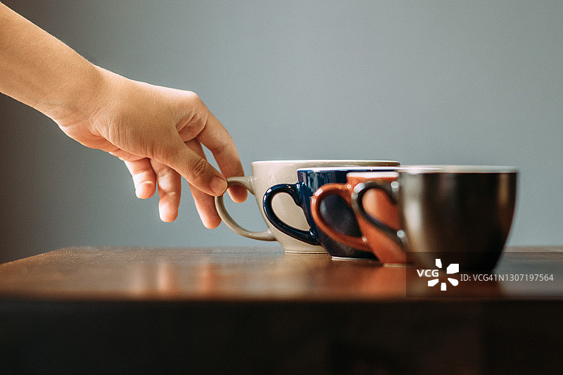 一排咖啡杯和一只手图片素材