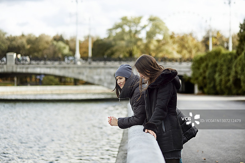 女人们站在城市河岸边图片素材