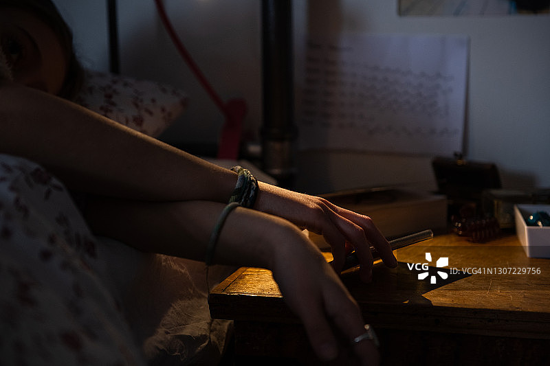 青少年伸手去拿床边的电话图片素材