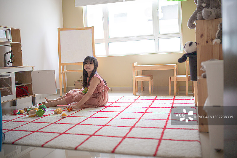 中国女孩在她的游戏室里独自玩耍图片素材