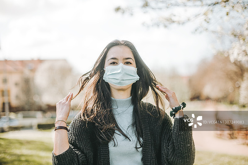 戴着防护口罩看向镜头的年轻女人图片素材