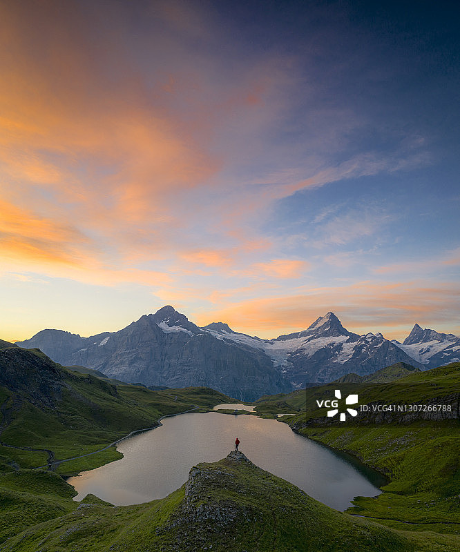 男子在瑞士拂晓时欣赏巴克阿尔普湖图片素材