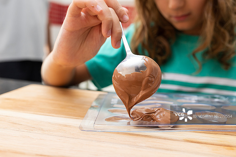 男孩用巧克力制作复活节兔子图片素材