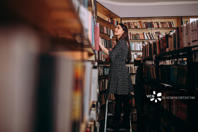 快乐的图书管理员在图书馆整理书籍图片素材