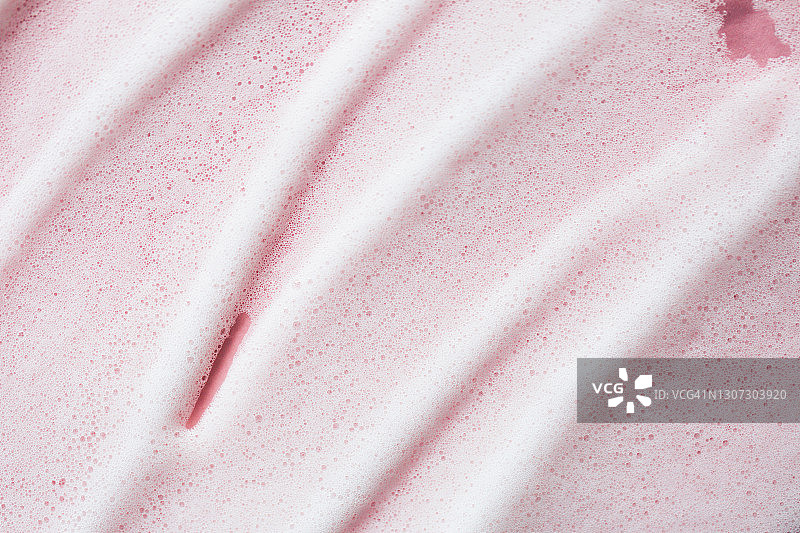 玫瑰背景上的白色泡沫纹理。自爱是年度潮流程序。带有复制空间的化妆品banner图片素材